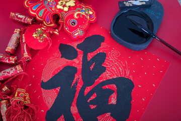 Chinese red spring couplets with Fu character and various decorations, inkstones and writing brushes