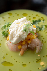 Pea and corn green cream soup with shrimps and expensive cheese in a fine dining restaurant, close up, macro texture