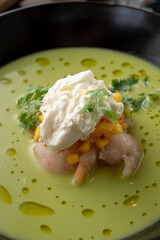 Pea and corn green cream soup with shrimps and expensive cheese in a fine dining restaurant, close up, macro texture