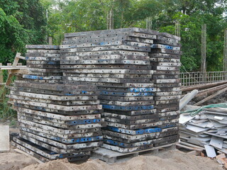 Piles of metallic molds for building a concrete fence at a construction site ready to be used