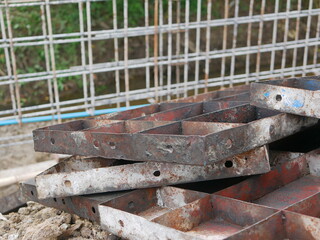 Pile of metallic molds for building a concrete fence at a construction site