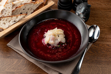Fine dining russian restaurant: cold borscht in a black designer bowl, modern russian cuisine
