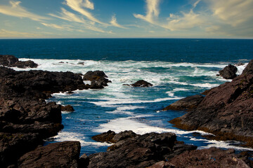 Obraz premium Waves crashing on the rocky shore of Ucluelet at sunset, Vancouver Island, Canada