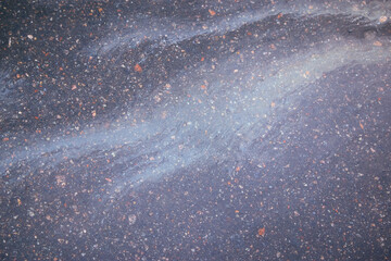 Abstract rainbow effect background, colorful gas stain on wet asphalt caused by a leak under a car or truck