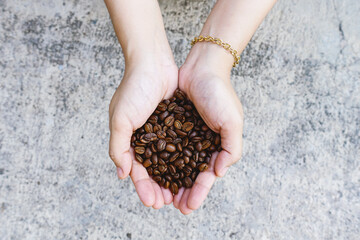 hands holding roasted coffee beans