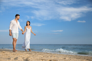 Fototapeta na wymiar Happy young couple walking together on beach
