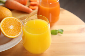 Glass of delicious juice and fresh ingredients on wooden table, closeup