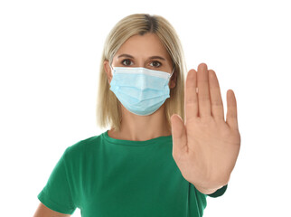 Woman in protective mask showing stop gesture on white background. Prevent spreading of coronavirus