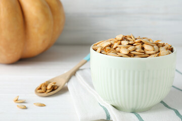 Raw pumpkin seeds on white table, closeup