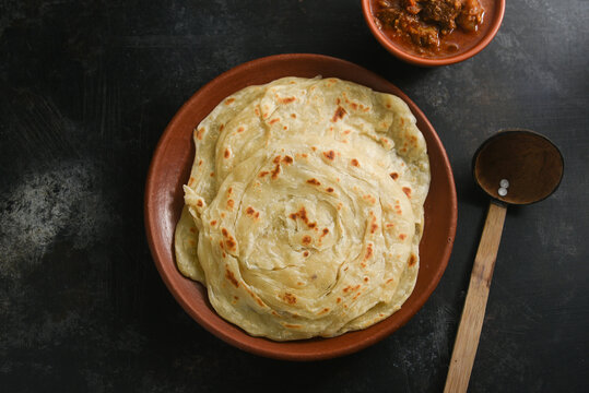 Kerala paratha porotta meat curry roti Malabar parotta barotta is Indian layered flatbread for breakfast or snack, popular street food in India. Maida or wheat flour Cooking the dough. 