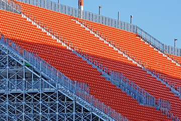 Side view of the grandstand of an open football stadium in the autumn sun