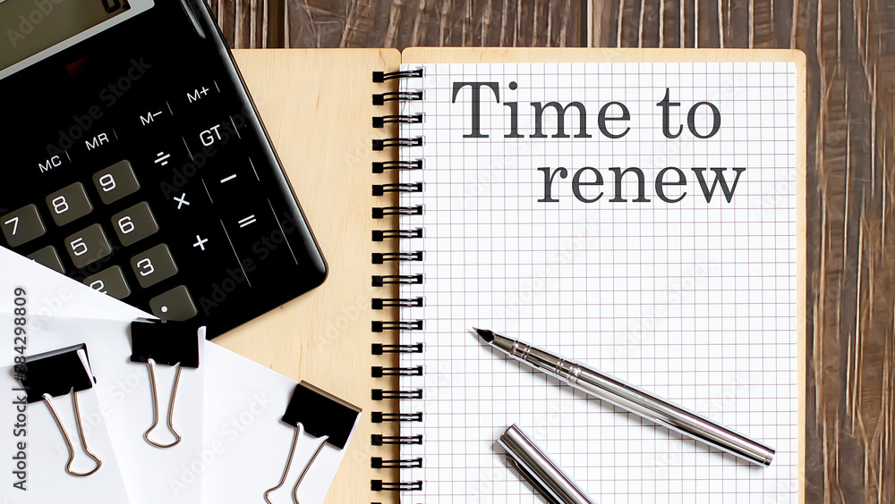 Poster notepad with text time to renew on the wooden background with clips, pen and calculator