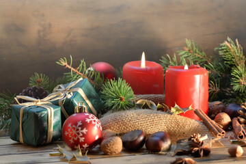 traditional christmas decoration on wooden background with candles and gifts