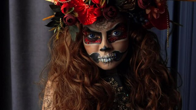 Beautiful Halloween Make-Up Style. Brunette Model Wear Sugar Skull Makeup with Red Roses. Santa Muerte concept