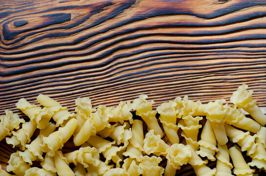 Dry gigli pasta on a wooden background.