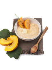 food photography of millet porridge with pumpkin in a clay bowl side view on a rustic wooden cutting board on white background isolated