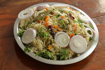 Indian vegetable biryani served in a plate on Wood background