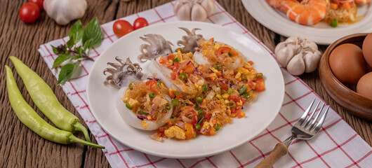 Stir fried glass noodles with squid in a plate on red white cloth