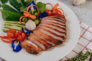 Sliced ​​fried pork with lemon, onion, red onion, tomato, long bean, butterfly pea flower, and mint.