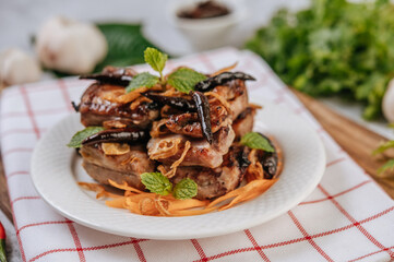 Fried Pork with Fried Chili Fried onion and mint in a white plate.