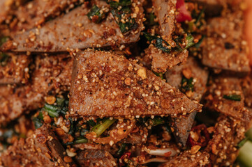 Pork liver salad with chili, roasted rice, spring onion, carrot, and cucumber.