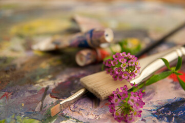 Obraz na płótnie Canvas art brushes on a palette with flowers