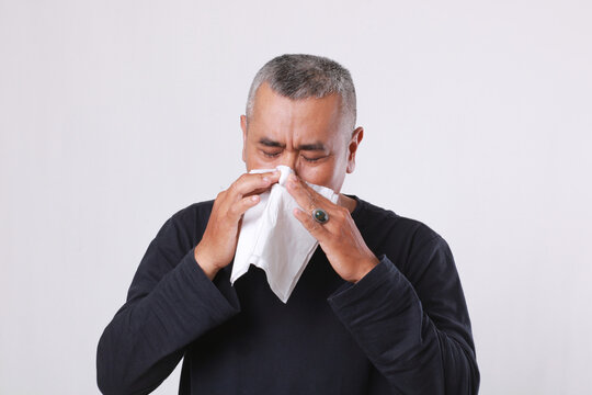 asian old man sick and sneeze with tissue paper isolated on white background