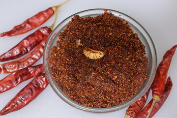 Dry hot red chillies powder on white background from top view.
