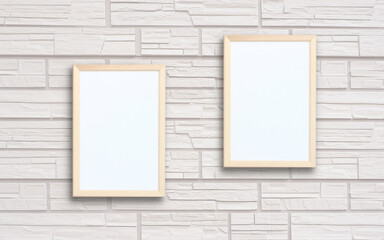 two empty rectangular frames on a neutral brick wall.