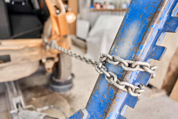 A broken car with a violation of geometry is on the stocks for leveling. Restoration of vehicles with chain and hook. Repair in the workshop and auto
