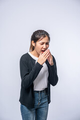 A woman coughing and covering her mouth with her hand