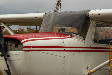 old small civil aircraft parked at the airport in the rain in autumn