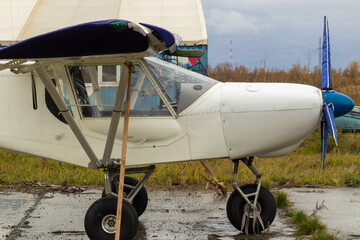old small civil aircraft parked at the airport in the rain in autumn