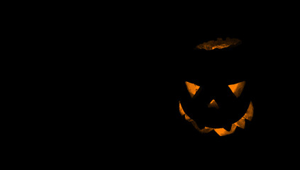 Pumpkin for Halloween glowing demon face in dark.  Scary Halloween pumpkin face 