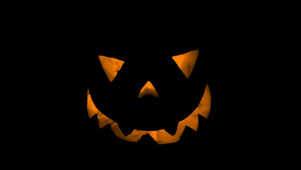 Fototapeta premium Pumpkin for Halloween glowing demon face in dark. Scary Halloween pumpkin face 