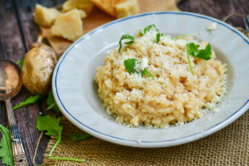 Risotto with mushrooms.Italian creamy  cheese risotto with parmesan cheese and fresh basil on rustic background