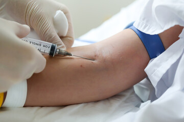 Nurse in latex gloves making child blood sampling from vein to test his health