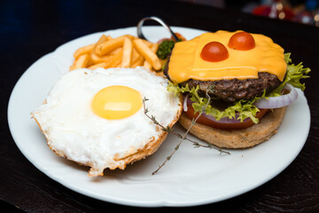 Cheeseburger with egg and french fries 