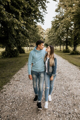 Vertical photo of romantic couple walking in embrance on nature background