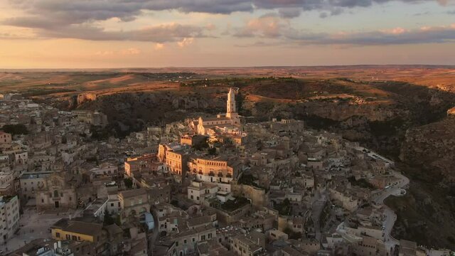 sassi di matera old town aerial view drone at sunset,flying orbit over city center at dusk