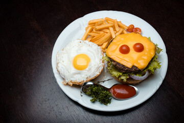 Cheeseburger with egg and french fries 