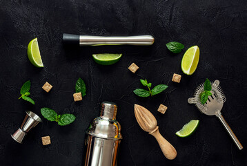 Mojito Cocktail Ingredients and tools on dark table.