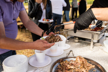 Man in black gloves put lamb with spatula for food