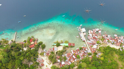 Fototapeta na wymiar Aerial view of village of fishermen with houses on the water, with fishing boats, Samal island. Philippines, Mindanao.