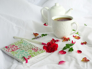 Still life with white dishes and rose petals