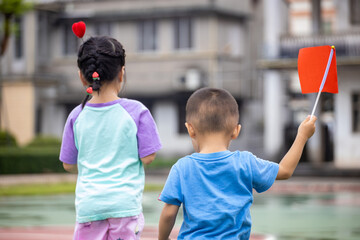 Children playing with red flags
