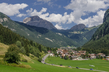 Campitello di Fassa village with Sella mountain group and Sassopiatto massif as seen from Dona valley, just before joining Fassa valley below, Dolomites, Trentino, Alto-Adige, South Tirol, Italy. © MoVia1
