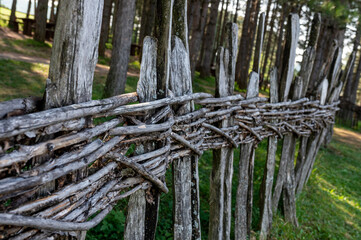 Old wooden wicker fence made of twigs in the countryside