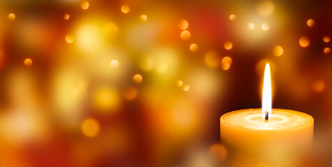 Obraz na płótnie Canvas brennende kerze mit bokeh lichtern in goldenen farben, festliches weihnachten konzept mit textfreiraum