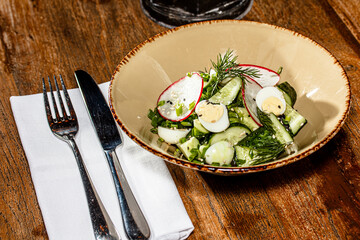 Cucumber, radish and egg salad is on the plate